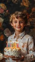 Young boy celebrates birthday with colorful cake and candles in a floral backdrop photo