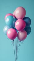 Colorful balloons in shades of pink and blue tied together against a bright blue background for a cheerful celebration photo