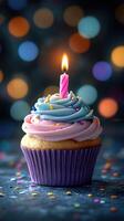 Colorful cupcake with a single candle against a blurred festive background celebrating a special occasion photo