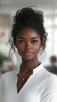 Young woman with natural hairstyle and white blouse smiling in a bright office setting during daytime photo