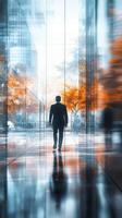 Businessman walking through modern architecture with vibrant autumn trees in urban setting photo