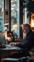 Man working intently at a desk during late afternoon with warm natural light streaming through the windows photo