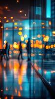 People in a modern building lobby silhouetted against vibrant lights during evening hours photo
