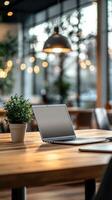Cozy workspace with a laptop, plant, and warm lighting in a modern cafe photo