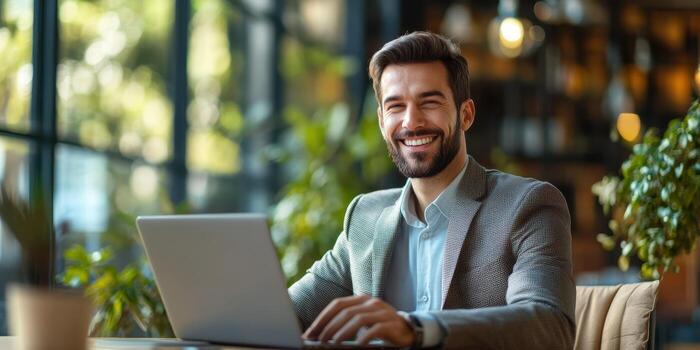 Successful young professional enjoying his work at a modern office space with greenery photo