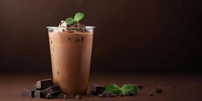 Delicious iced chocolate drink topped with mint leaves and chocolate shavings on a dark background photo