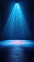 Bright blue spotlight illuminates an empty stage in a dark room, creating a captivating atmosphere for performance photo