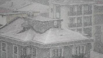 Heavy snowfall blanketing urban rooftops in winter video