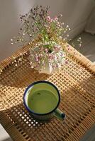 Cup of tea and blooming gypsophila on wicker table photo