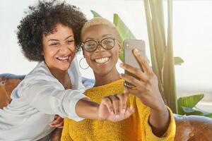 Smiling multiracial women taking selfie on smartphone photo