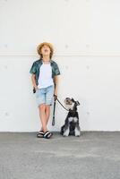 Stylish boy screaming with dog on sidewalk photo
