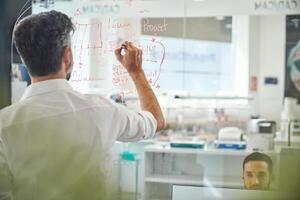 Unrecognizable man working at laboratory with scheme photo