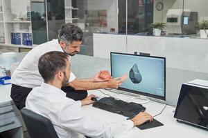 Engineers designing respirator on computer photo