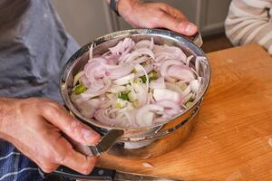 Unrecognizable person with pot of chopped onion photo