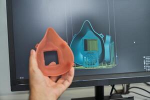 Crop person comparing 3d figure of respirator and 3d model on sc photo