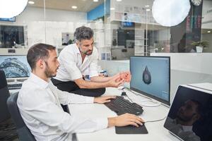 Men designing respirator on computer photo