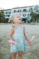 Funny curious girl blowing soap bubbles and entertaining on summ photo