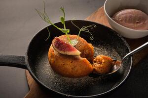 Frying pan with sweet cake near bowl of ice cream photo