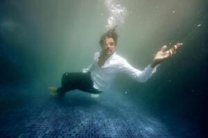 Sad man drowning in water in pool photo