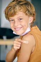 Cheerful boy with patch and medical mask photo
