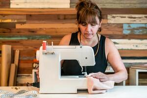 Fashion designer using sewing machine at her studio photo