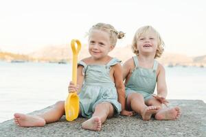 Happy kids playing with toy on beach photo