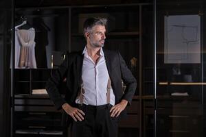 Mature businessman in suit standing at home photo