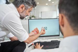Engineers with 3D model of respirator near computer photo