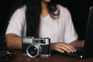 Analog camera and laptop old and new technology. photo