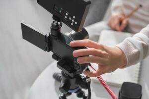 Crop person setting up camera for recording photo