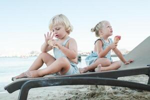 Children enjoying ice cream on sandy beach photo