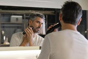 Man shaving in bathroom at home photo