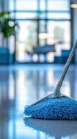 Cleaning process in a bright and modern lobby using a blue mop on shiny floors during daylight hours photo