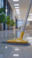 Cleaning a modern office space with a yellow mop while bright lights illuminate the environment photo