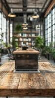 Modern workspace with a laptop on a wooden table surrounded by plants in a bright, open office environment photo