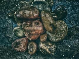 Rocks and pebbles on a dark surface photo
