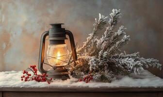 A lantern is lit and sits on a table with a pine branch and berries photo