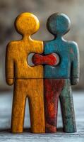 A wooden puzzle piece with two people on it. The puzzle piece is missing a piece, and the two people are holding each other's hands. Concept of unity and togetherness photo