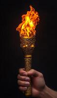 Holding a flaming torch in the dark. A person holds a stunning torch, its flickering flame illuminating the darkness and setting an intense mood. photo