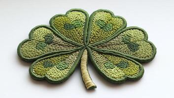 Intricate four-leaf clover patch. This patch features a beautifully stitched four leaf clover, showcasing various shades of green in its design. photo