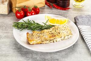 A plate of food with a lemon wedge and a slice of tomato photo