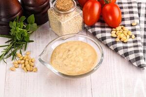 A bowl of mustard and a bowl of tomatoes photo