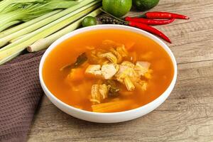A bowl of soup with vegetables and a knife photo