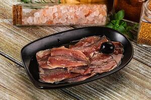 A bowl of meat and spices on a wooden table photo