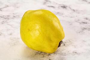 A yellow fruit on a white surface photo