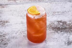 A drink with an orange slice in it photo