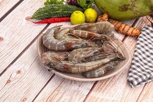 A bowl of shrimp and vegetables on a table photo