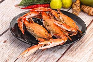 A plate of crabs and vegetables on a wooden table photo