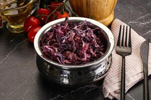 A bowl of red cabbage with a knife and fork photo