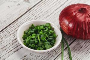 A bowl of chopped onions and a red onion photo